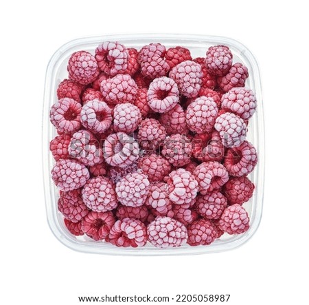 Plastic container with frozen raspberry. Top view of raw fruits isolated on white background. Storage for winter storage in trays