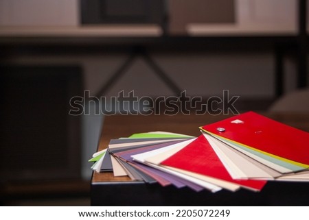 a color selection catalog lying on a table in the office of a furniture factory, against a blurred background of mdf furniture asads