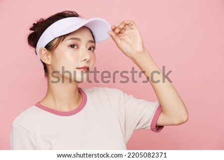 Portrait of young Asian woman in sporty fashion on pink background Royalty-Free Stock Photo #2205082371
