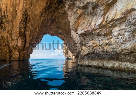The Blue Grotto is a complex of sea caves along the Southeastern part of Malta, and on sunny days, the reflection of sunlight on the white sandy seafloor lights up the caves in bright blue hues Royalty-Free Stock Photo #2205088849