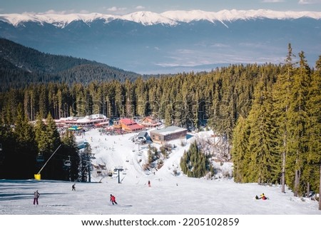Winter landscape with panorama of Bansko above the clouds. Famous ski resort in Bulgaria. View of the ski slopes and the Pirin Mountains Royalty-Free Stock Photo #2205102859