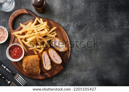 Cordon bleu and french fries. Chicken cordon bleu schnitzel, meat wrapped around ham and cheese, breaded and fried. Royalty-Free Stock Photo #2205105427