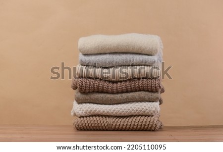 Closeup stack of warm sweaters on brown background 

 Royalty-Free Stock Photo #2205110095