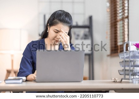 Asian women are stressed while working on laptop, Tired asian businesswoman with headache at workplace, feeling sick at work, copy space Royalty-Free Stock Photo #2205110773