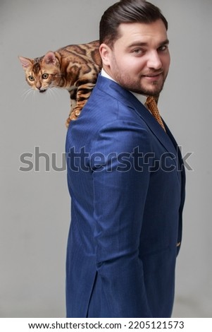 Handsome businessman with bengal cat in white background