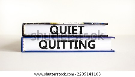 Quiet quitting symbol. Concept words Quiet quitting on books. Beautiful white table white background. Business and quiet quitting concept. Copy space.