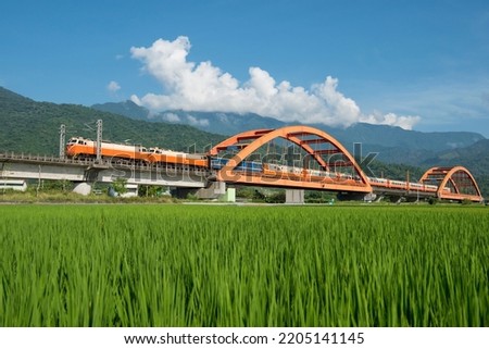 Train iron bridge over the paddy field background mountain in Yuli Town,Hualien County,Taiwan. Royalty-Free Stock Photo #2205141145