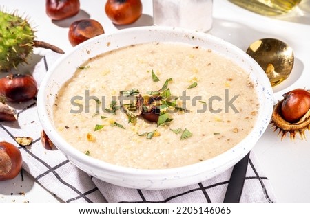 Homemade roasted chestnut soup. Autumn cream soup with chestnuts on white background Royalty-Free Stock Photo #2205146065