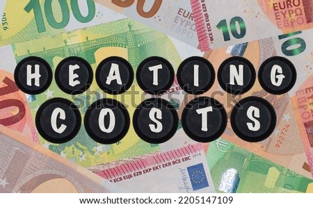the words heating costs next to euro banknotes. Increase in heating prices and the energy crisis in Europe