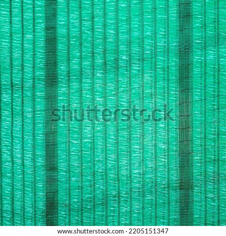 Green shading net surface for protection from sunlight, there is a hole for the wind to pass through for use in agriculture.