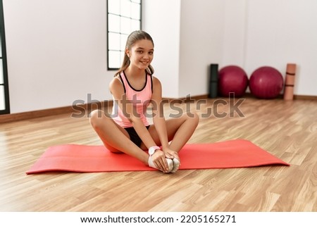 Adorable girl smiling confident stretching at sport center
