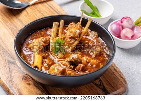 Mutton curry or Mutton gravy is a delicious indian curried dish of soft tender chunks of meat in spicy onion tomato gravy Royalty-Free Stock Photo #2205168763