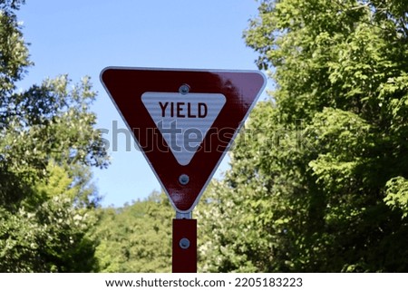 The red and white yield sign on the side of the road.