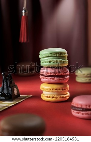 Stack of colored macaroons with different flavors - pistachio, raspberry, lemon. Creative advertisement for macaron product in retro style. French biscuit macaroon cookies in the spotlight
