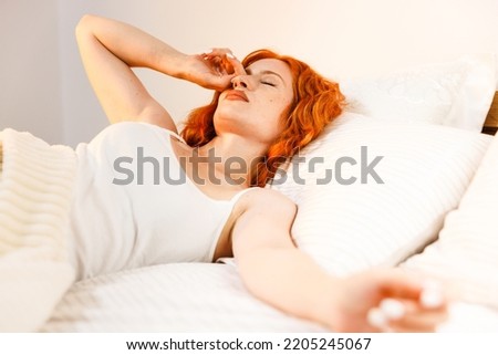 Top view portrait of cheerful positive woman waking up enjoying bed time in the morning keeping eyes closed health healthy