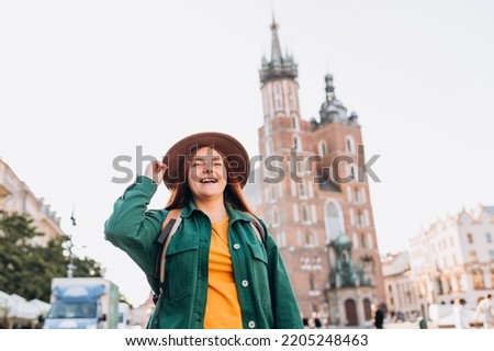 Famous cathedral in sun light, Tourist happy woman on Market Square in Krakow, Traveling Europe in autumn. St. Marys Basilica