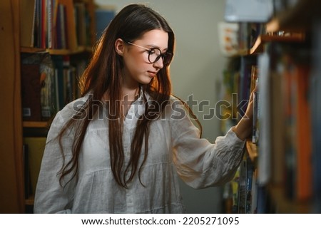 Portrait of a student girl studying at library.