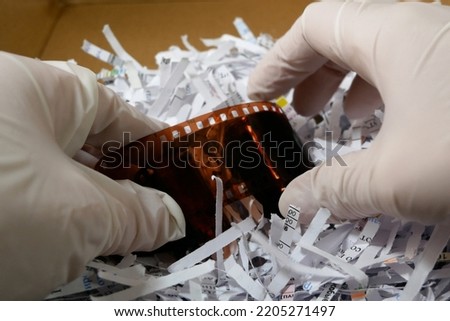 Photo Film Rolls among shredder paper, thief information concept, Top secret information, concept, closeup