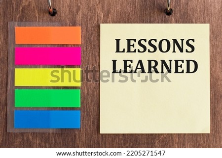 LESSONS LEARNED text on wooden background. business and education concept