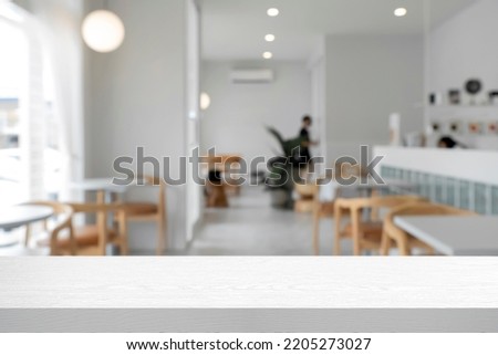 Empty wooden table space platform and blurred cafe or restaurant background for product display montage. Royalty-Free Stock Photo #2205273027