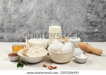 Kitchen background for baking and making cake,bread,confectionery and ingredients for cooking,milk,honey,flour,salt,sugar,eggs and cream on concrete background with place for text,selective focus,