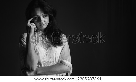 Black and white classic photo. Portrait of sad upset frustrated girl, young lonely desperate woman holding her head with hand, suffering from hard life, problems or headache. Despair, depression