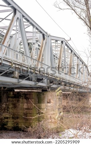Gray metal train bridge over river.