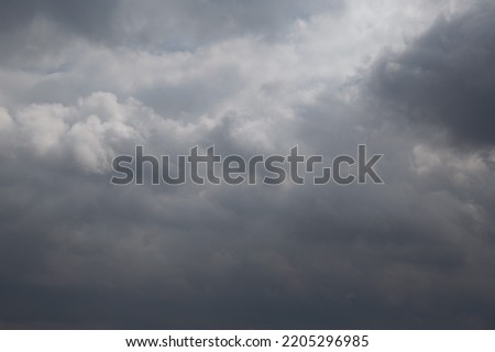 Blue sky in the gap between dark rain clouds Royalty-Free Stock Photo #2205296985