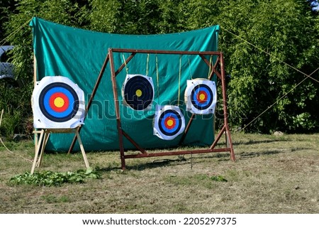 A close up on three targets used for arrow shooting practice hanging from ropes or strings and attached to a wooden frame seen during a local archery competition in summer in Poland