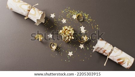 Image of christmas crackers, stars and decoration on grey background. Christmas, tradition and celebration concept.