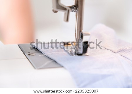 A man sews clothes on a sewing machine. Hobbies, needlework, creativity.