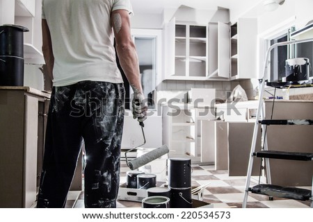 Mess of All kind of Painting Equipment in the Kitchen and Discouraged Man Royalty-Free Stock Photo #220534573