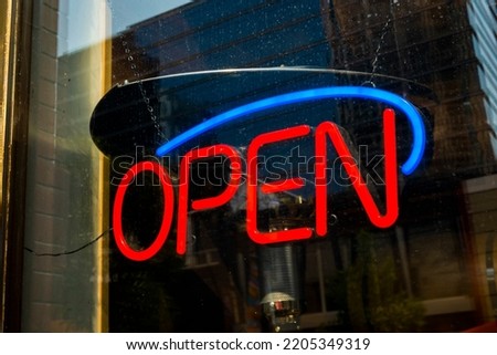 An neon open sign in a window of a business. 