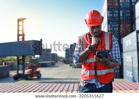 Foreman using tablet and walkie talkie radio control loading containers box. Engineer or worker with safety hat work at container cargo site and checking industrial container cargo freight ship.