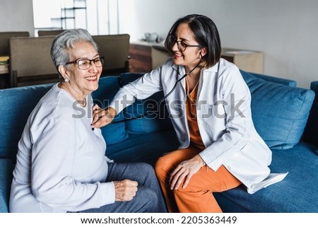 hispanic elderly woman with doctor or nurse during home visit in Mexico Latin America Royalty-Free Stock Photo #2205363449