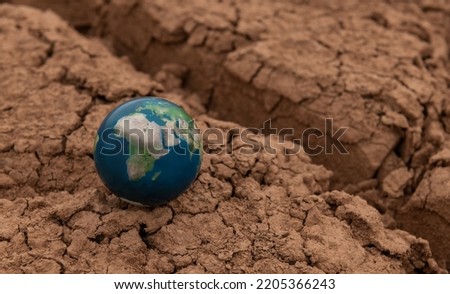 Miniature globe depicting Africa and Eurasia on dry cracked clay in the desert
