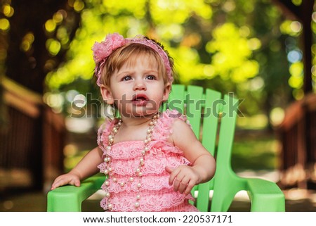 One year old girl playing outside in a pink romper -- image taken at San Rafael park in Reno, Nevada