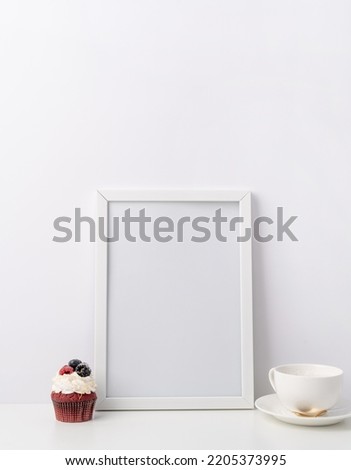 Art photo frame mockup with cup of coffee and cupcake, white background template