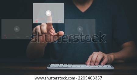 Young man using computer and touching on virtual screen online streaming video on internet.