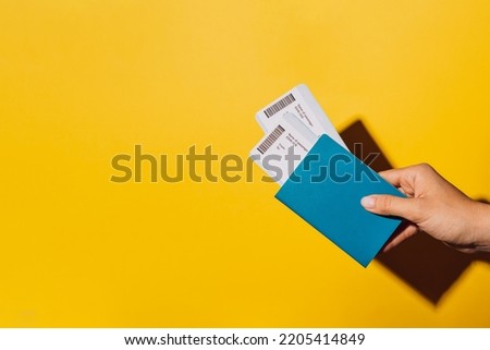Two tickets in the passport against yellow background. Royalty-Free Stock Photo #2205414849