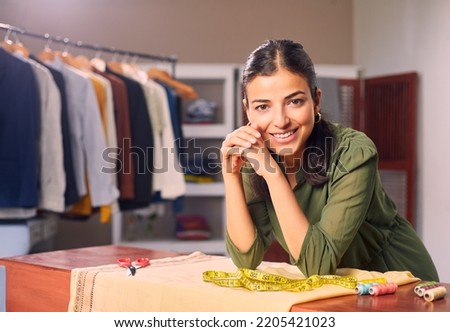 A Modern Happy smiling Young attractive Indian Asian woman or female professional fashion stylist standing in a designer boutique store and looking at the camera. self-employment and startup concept. Royalty-Free Stock Photo #2205421023
