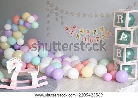 happy birthday decoration for kids with colored balloon and rocking horse chair close up photo
