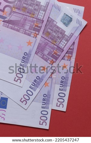 500 euro banknotes on a red background close up