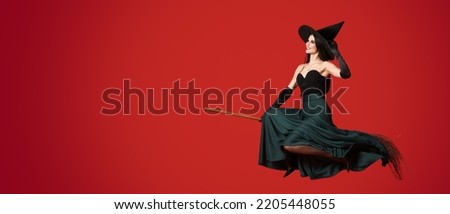Young witch flying on broom against red background with space for text Royalty-Free Stock Photo #2205448055