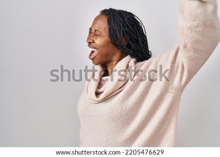 African woman standing over white background dancing happy and cheerful, smiling moving casual and confident listening to music 