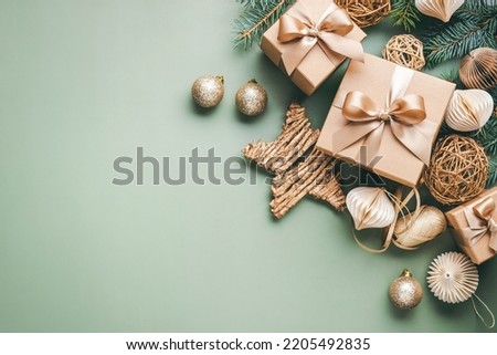 New Year card with Christmas gift boxes and golden decorations on khaki background.