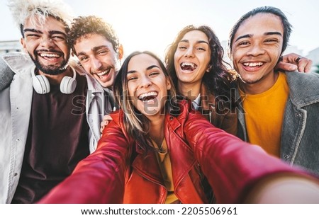 Happy multiracial friends taking selfie picture with smart mobile phone device outdoors - Cheerful young people smiling together at camera - University students having fun in college campus 