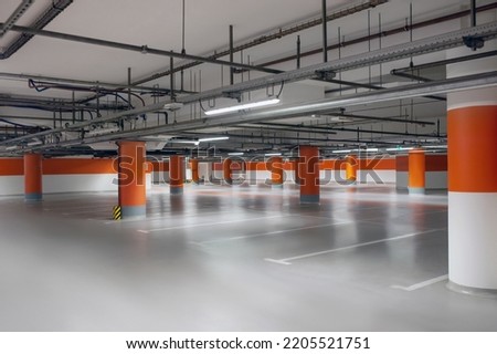 Empty car parking garage with lighting and columns Royalty-Free Stock Photo #2205521751