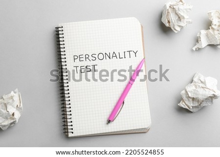 Notebook with text Personality Test, pen and crumpled sheets of paper on light background, flat lay