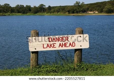 A funny sign reads "DANGER, LAKE AHEAD" at the end of a road that leads to Lake Meridian